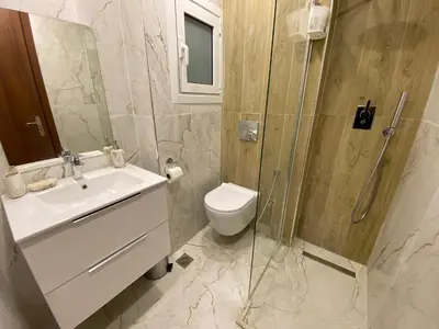 a bathroom with a toilet and a sink and a shower at Nafousa 1. Nafousa 2 in Athens