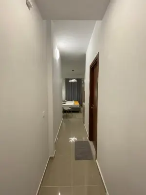 a hallway with white walls and a room with a bed at Nafousa 1. Nafousa 2 in Athens