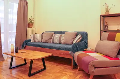 a living room with a blue couch and a table at Cozy Apartment Downtown in Athens