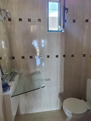 a bathroom with a toilet and a sink and a mirror at John's modern apartments artemida in Artemida
