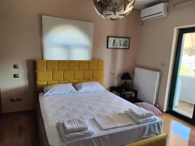 a bedroom with a large bed with two towels on it at John's modern apartments artemida in Artemida