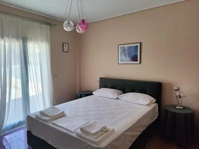 a bedroom with a bed with towels on it at John's modern apartments artemida in Artemida