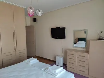a bedroom with a bed and a mirror and a tv at John's modern apartments artemida in Artemida