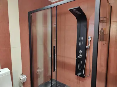 a shower in a bathroom with a black shower at John's modern apartments artemida in Artemida