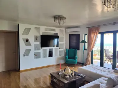 a living room with a couch and a tv at John's modern apartments artemida in Artemida