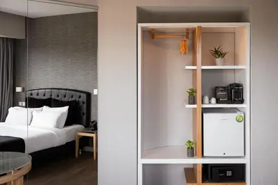 a hotel room with a bed and a room with aiger at Kreoli Suites Glyfada in Athens