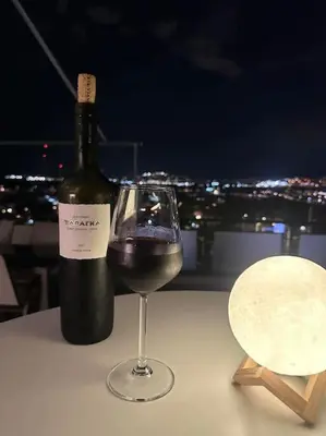 a bottle of wine and a wine glass on a table at Floisvos Penthouse Oasis in Athens