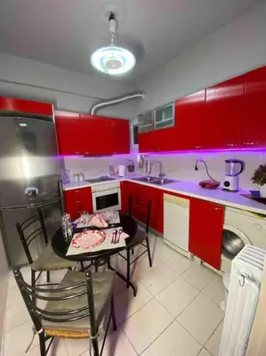 a kitchen with red cabinets and a table and chairs at Frankie's House in Athens