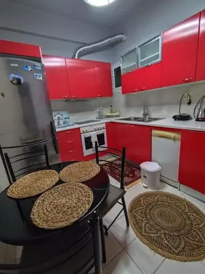 a kitchen with red cabinets and a table and chairs at Frankie's House in Athens