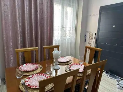 a dining room table with four chairs and a table with dishes on it at Frankie's House in Athens