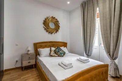 a bedroom with a bed with a mirror on the wall at De lenco Residence 2 in Athens