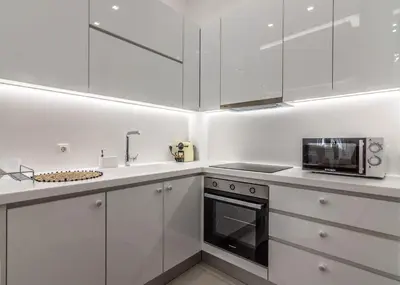 a white kitchen with white cabinets and a microwave at De lenco Residence 2 in Athens