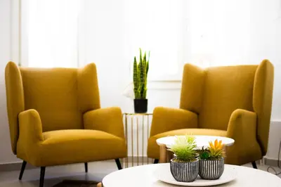 two yellow chairs and a table in a room at De lenco Residence 2 in Athens