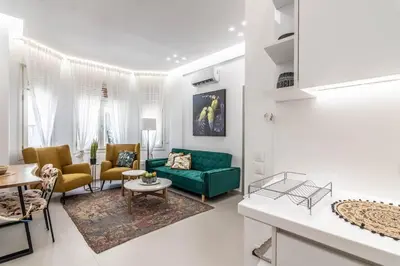 a living room with a green couch and chairs at De lenco Residence 2 in Athens