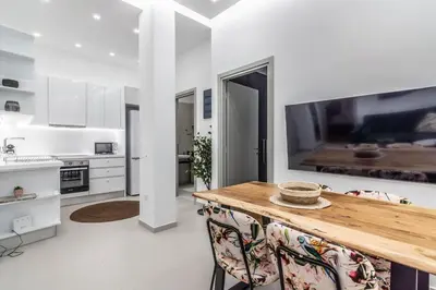 a kitchen with a table and a large tv on the wall at De lenco Residence 2 in Athens
