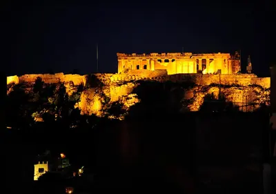 a building on top of a mountain at night at Live in Athens, PSYRRI Central Apartments in Athens
