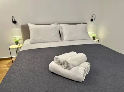 a bedroom with a bed with towels on it at Relax Home In Moschato 2 VIPGreece in Piraeus