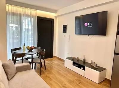 a living room with a table and a tv on the wall at Relax Home In Moschato 2 VIPGreece in Piraeus