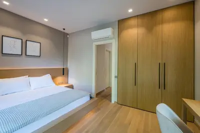 a bedroom with a bed and a wooden cabinet at Amazing Stay in Athens