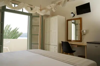 a bedroom with a bed and a mirror and a desk at Kores Aegina in Agia Marina Aegina