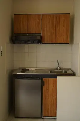 a kitchen with a sink and a stove and cabinets at Kores Aegina in Agia Marina Aegina