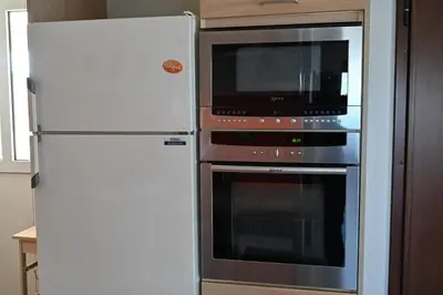 a kitchen with a microwave and a refrigerator at Vasiliki’s Guesthouse in Athens