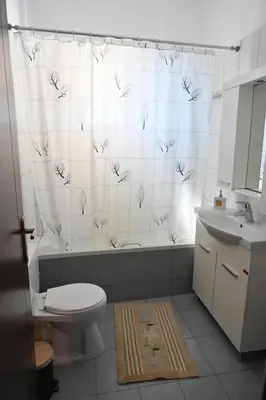 a bathroom with a toilet and a tub and a sink at Vasiliki’s Guesthouse in Athens