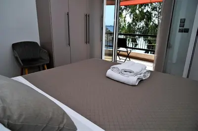 a bed with two towels sitting on top of it at Sea Luxury Apartments in Piraeus