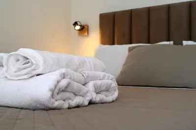 a pile of white towels sitting on a bed at Sea Luxury Apartments in Piraeus
