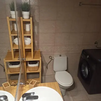 a bathroom with a toilet and a sink and a washing machine at Apartamento Central - La Amistad in Athens