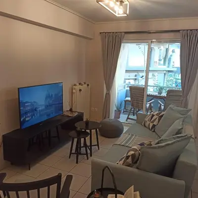 a living room with a couch and a flat screen tv at Apartamento Central - La Amistad in Athens