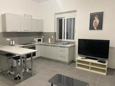 a kitchen with a tv and a table and a tvicter at Leo's Apartments in Koropíon