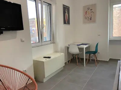 a living room with a tv and a table and chairs at Leo's Apartments in Koropíon