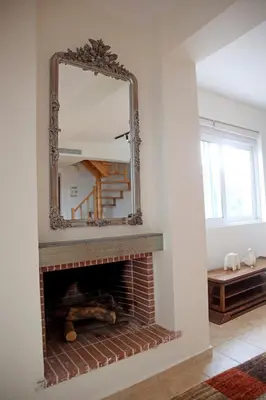 a mirror over a fireplace in a living room at Sunset Sea View Maisonette Anavissos in Anavissos
