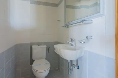 a bathroom with a white toilet and a sink at Sunset Sea View Maisonette Anavissos in Anavissos