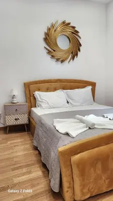 a bedroom with a large bed and a mirror at De lenco Residence 4 in Athens