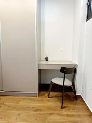 a desk with a chair next to a white wall at Moschato New Home 3 VIPGreece in Piraeus