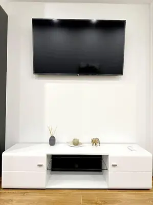 a white entertainment center with a flat screen tv on a wall at Moschato New Home 3 VIPGreece in Piraeus
