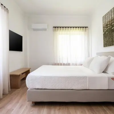a white bedroom with a bed and a window at 4BD Apartment with Outdoor Jacuzzi Garden in Athens