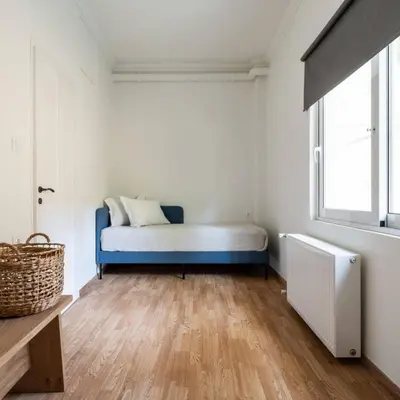 a bedroom with a blue bed and a window at 4BD Apartment with Outdoor Jacuzzi Garden in Athens