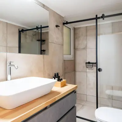 a bathroom with a white sink and a shower at 4BD Apartment with Outdoor Jacuzzi Garden in Athens