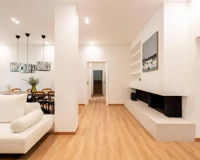 a living room with a white couch and a fireplace at 4BD Apartment with Outdoor Jacuzzi Garden in Athens