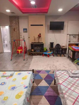 a living room with a play room with a fire place at House marios airport in Spáta