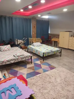 a room with two beds and two tables in it at House marios airport in Spáta