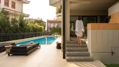 a woman walking down the stairs of a house at Sol Residence - Private Pool Gym Glyfada in Athens