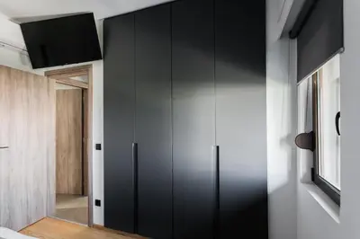 a large black cabinet in a room with a hallway at Sol Residence - Private Pool Gym Glyfada in Athens