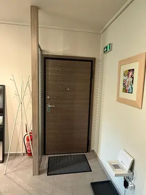 a brown door in a room with a sign on the wall at Charming apartment in Glyfada in Athens