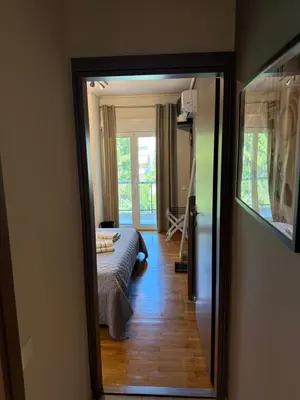 a view of a bedroom with a bed and a mirror at Charming apartment in Glyfada in Athens