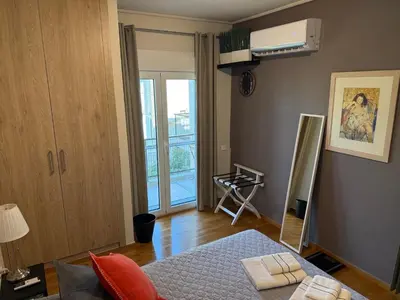 a bedroom with a bed and a mirror and a window at Charming apartment in Glyfada in Athens