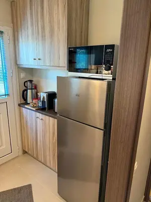 a kitchen with a stainless steel refrigerator and a microwave at Charming apartment in Glyfada in Athens